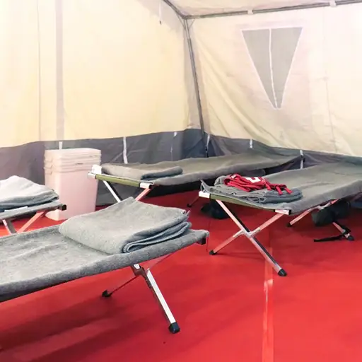 Interior photo of civil defense tent with prepped cots